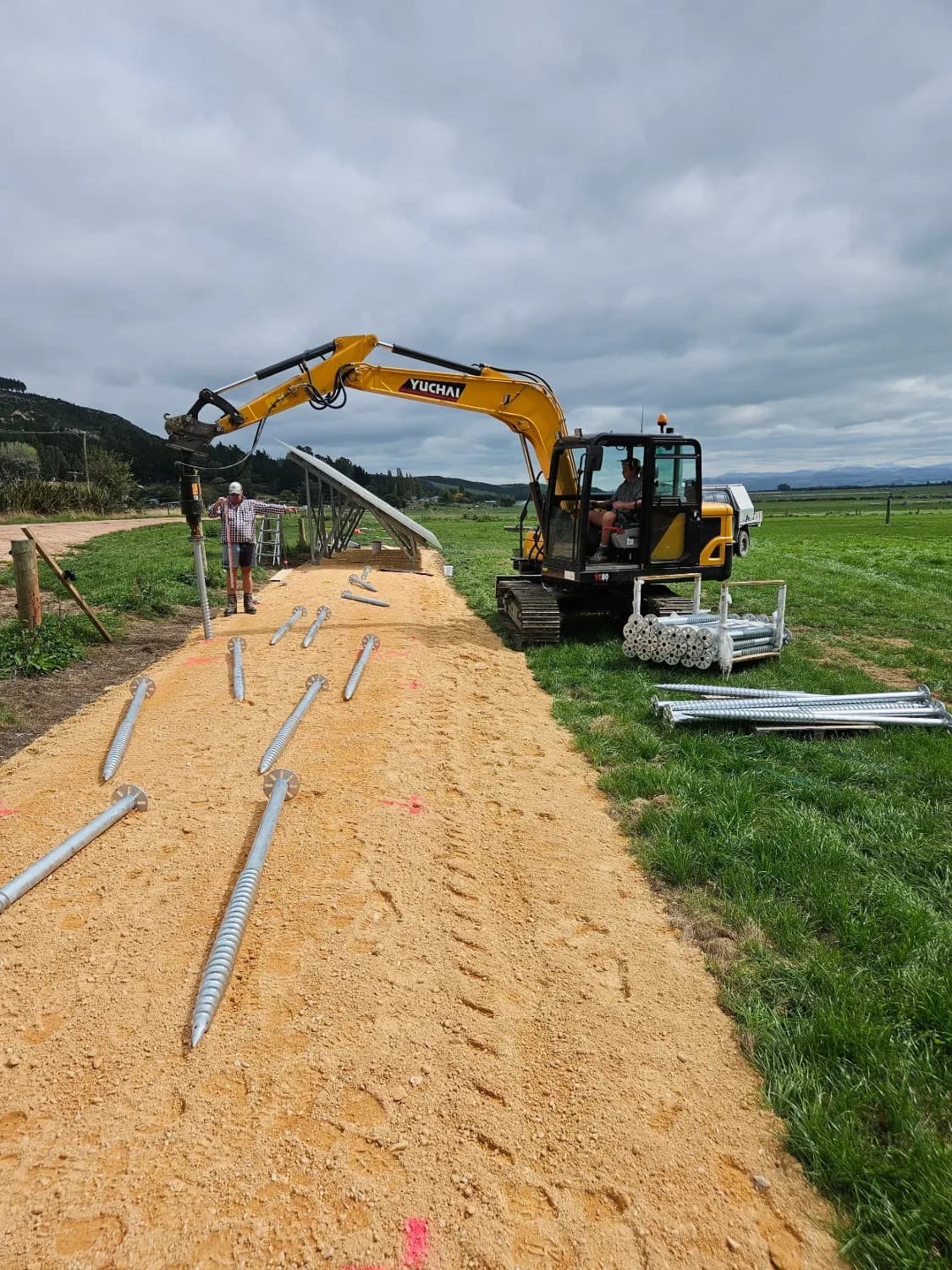 Yuchai YC80 excavator installing screw piles for a solar array
