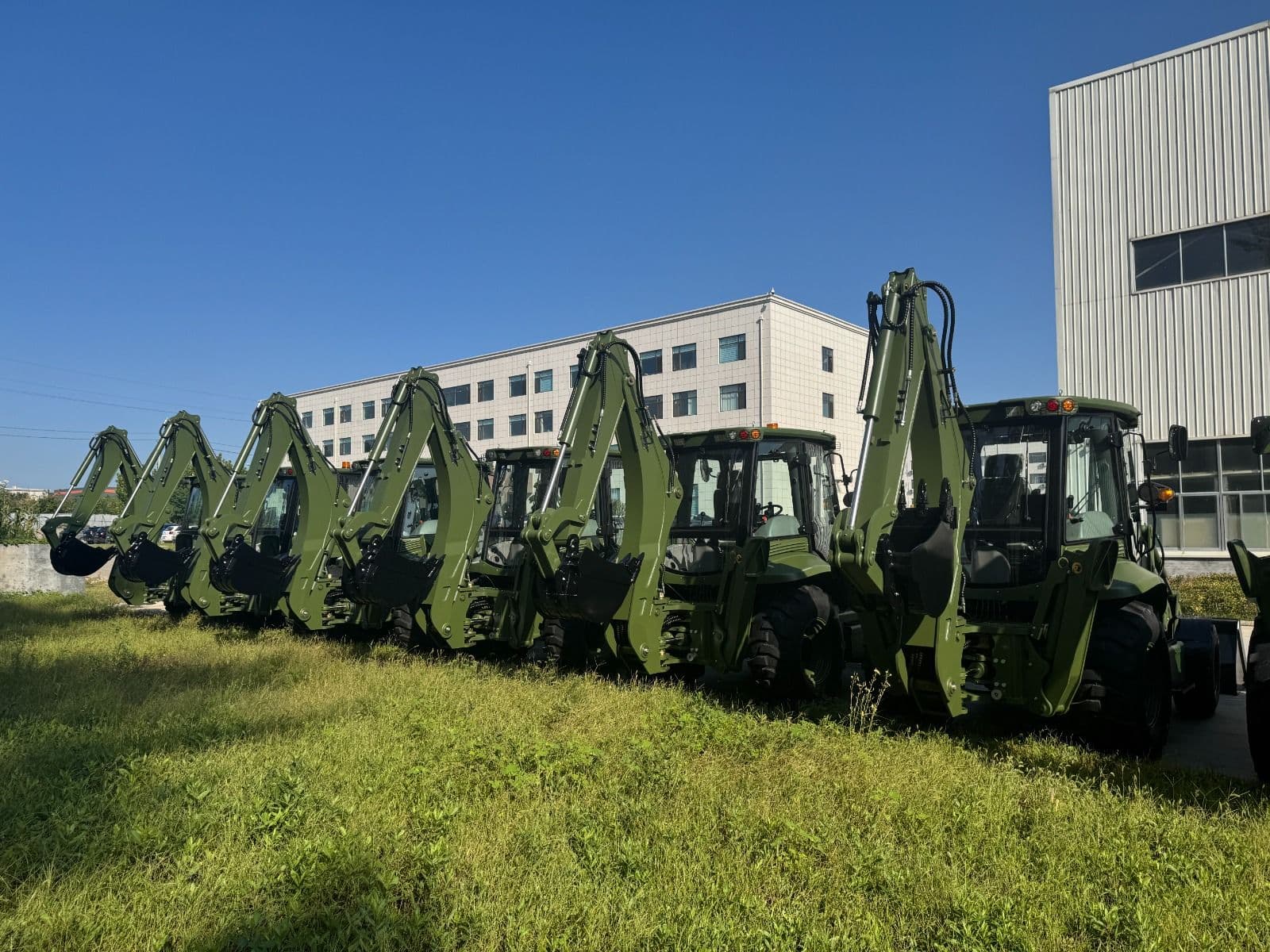 Line-up of MCM 388 TLB backhoe loaders in green