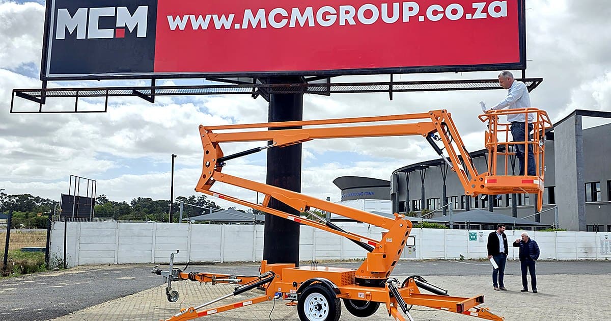 MCM towable cherry picker (trailer-mounted towable boom lift) working on a billboard