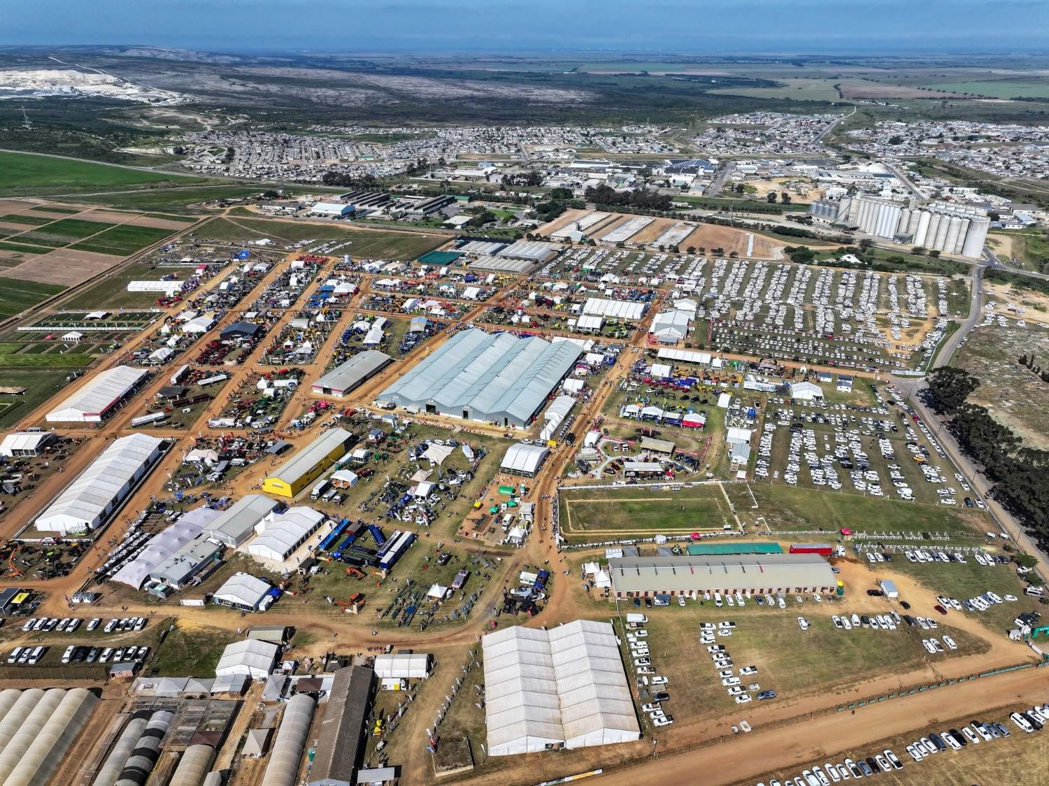 Aerial view of NAMPO Cape 2026 at Bredasdorp Park, with the exhibition halls, outdoor stands and the Bredasdorp grain silos